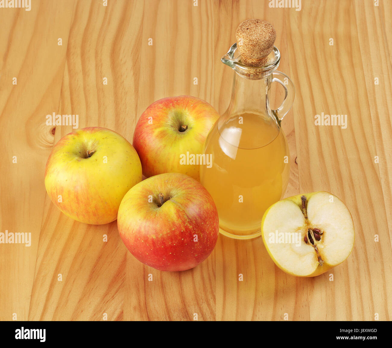 Apple cider vinegar and fresh apple on a wooden background. Stock Photo