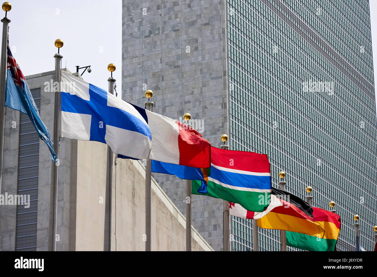 national flags flying at the united nations secretariat tower building New York City USA Stock Photo