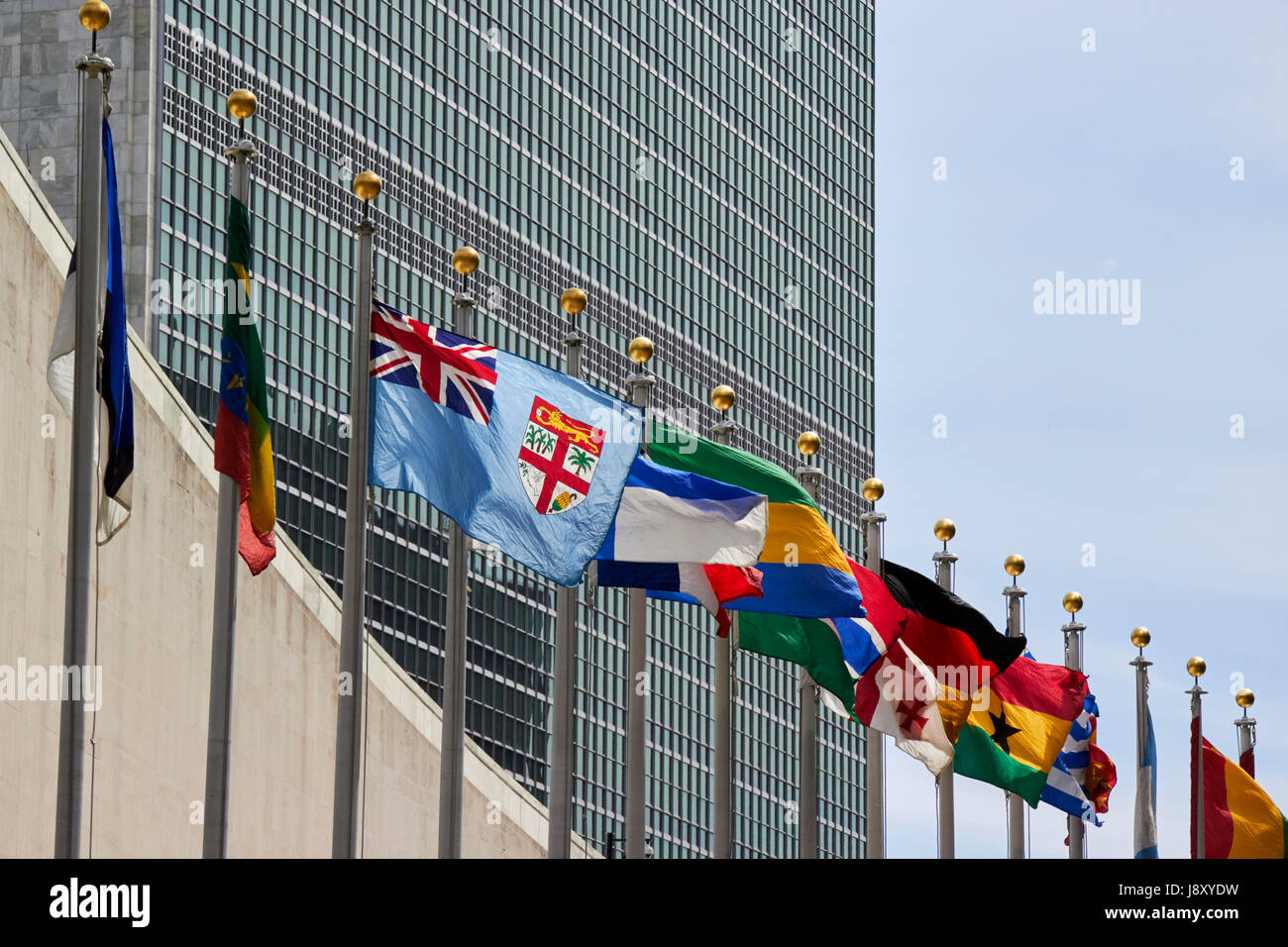 national flags flying at the united nations secretariat tower building New York City USA Stock Photo