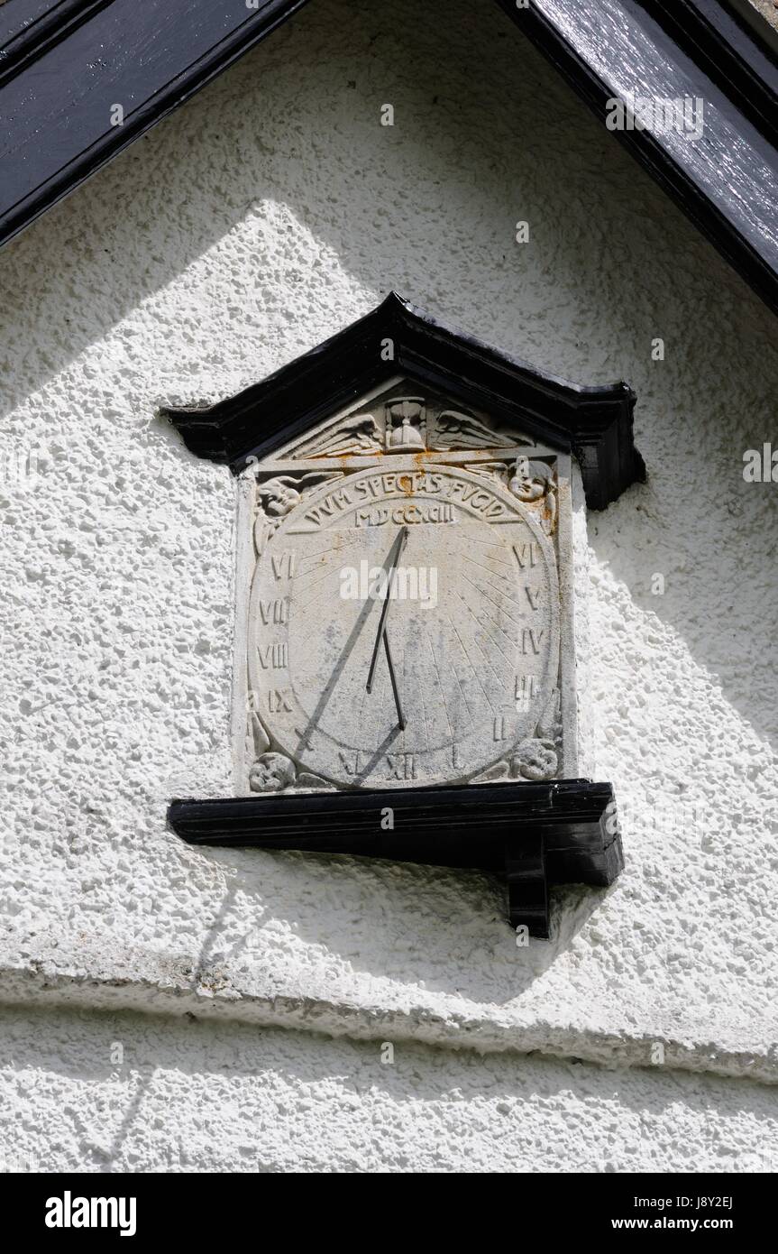 Sun Dial,Westmill, Hertfordshire, carved with an egg timer, faces, and the hours in Roman numerals on its face. Stock Photo
