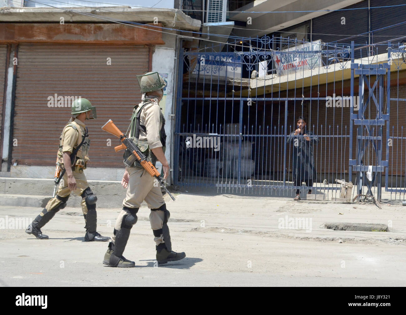 Srinagar, India. 30th May, 2017. A possee of Indian paramilitary personnel passes by a local during curfew in Kashmir. Curfew has been put in plcae in Kashmir on third day to counter the protests against the killing of Kashmiri Rebel Sabzar in an encounter with Indian Forces in Tral area of Kashmir on Saturday. Credit: Muzamil Mattoo/Pacific Press/Alamy Live News Stock Photo