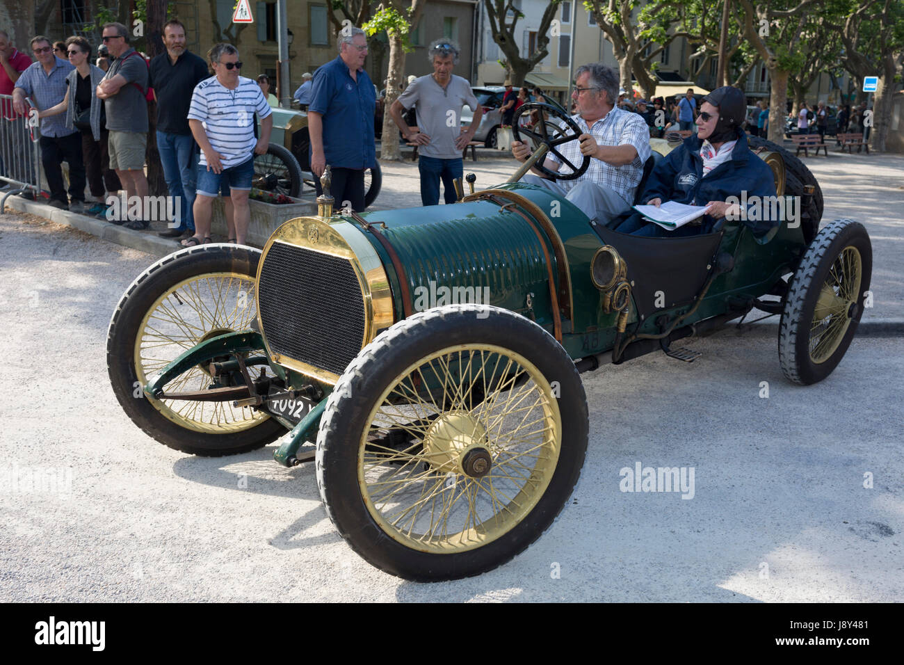 A visiting vintage car leaves a French village, during a three-day rally journey through the Corbieres wine region, on 26th May, 2017, in Lagrasse, Languedoc-Rousillon, south of France. Lagrasse is listed as one of France's most beautiful villages and lies on the famous Route 20 wine route in the Basses-Corbieres region dating to the 13th century. Stock Photo