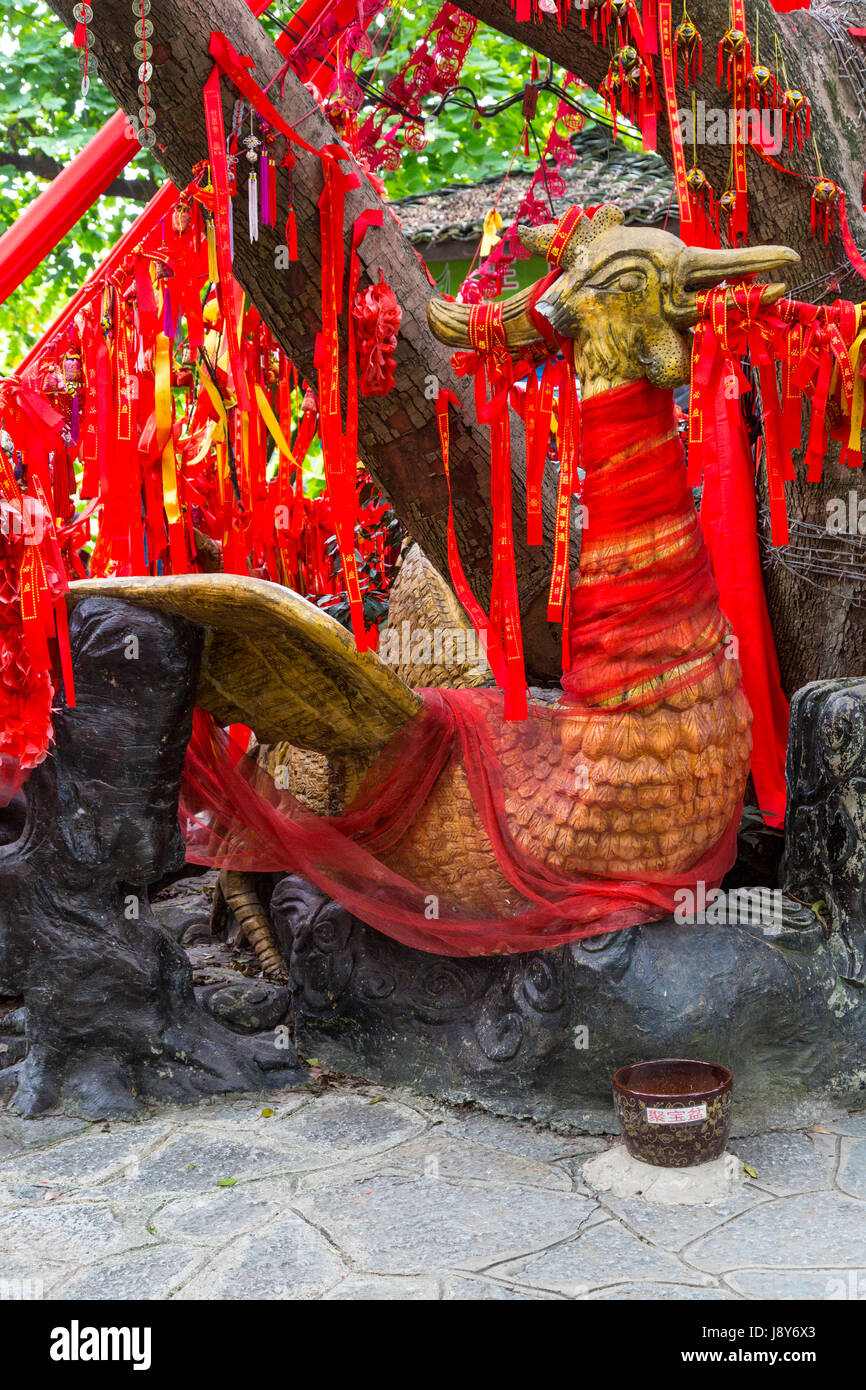 Guilin, China.  Elephant Trunk Hill Park.  Chinese Phoenix Surrounded by Red Ribbons Requesting a Wish. Stock Photo