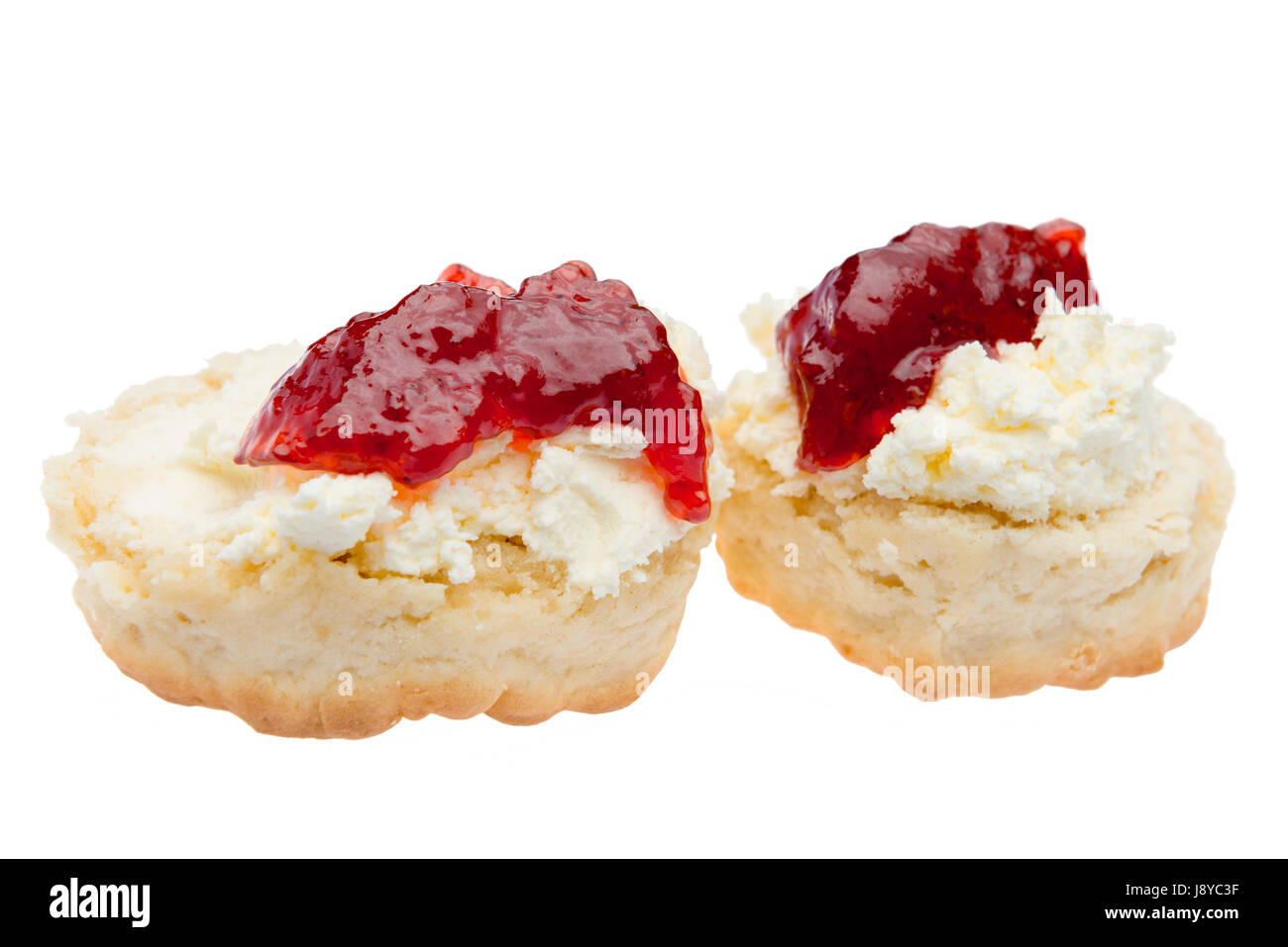 Scone with whipped cream and strawberry jam, cut out or isolated against a white background. Stock Photo
