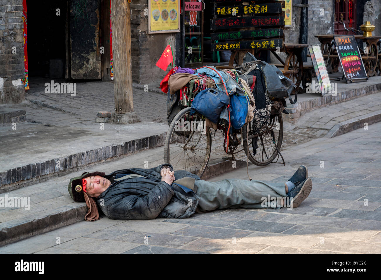 [Image: man-sleeping-on-the-road-next-to-his-bic...J8YG2C.jpg]