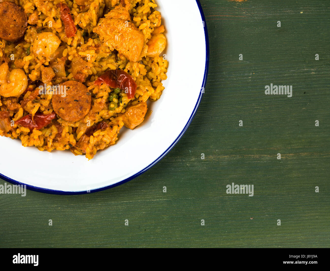 Chicken Smoked Chorizo and King Prawn Paella Meal Against a Green