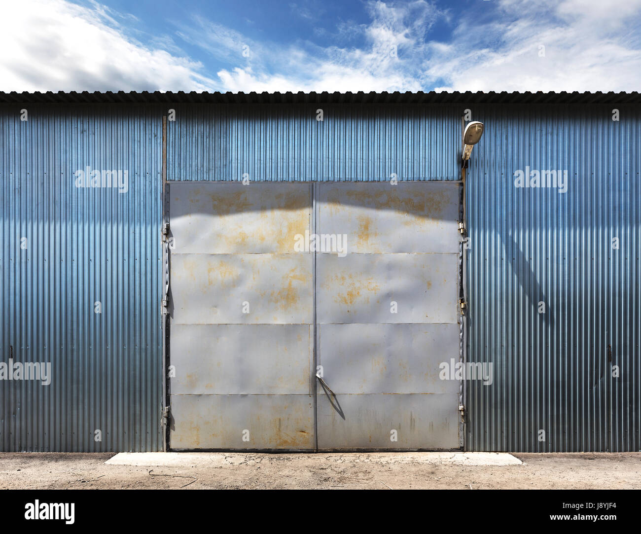 Photo Of Old Grunge Closed Warehouse Blue Sky On Background Stock