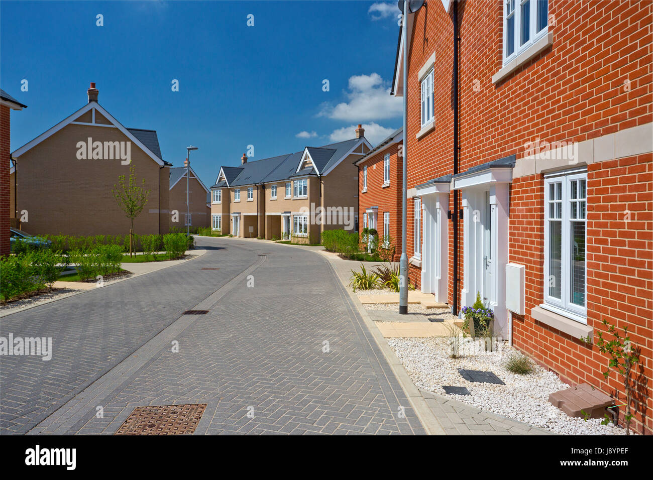 An empty street in a mostly complete new housing development Stock ...