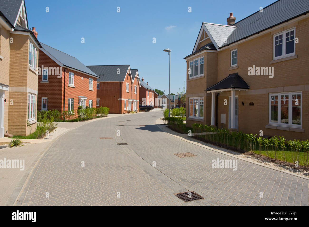 An empty street in a mostly complete new housing development, with ...