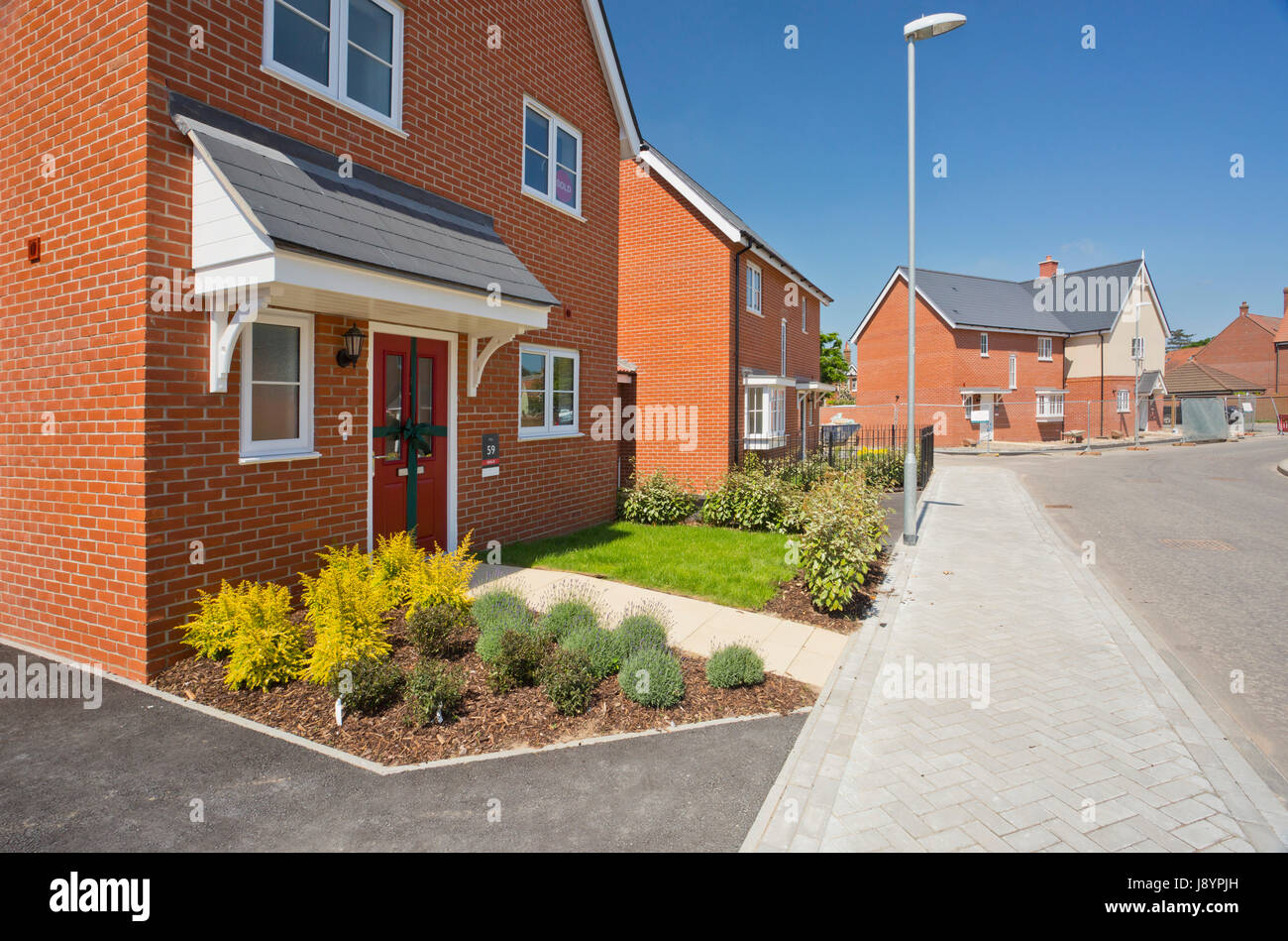 An empty street in a mostly complete new housing development, with ...