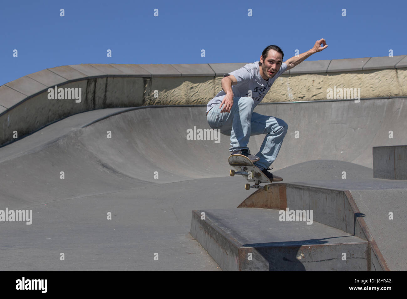 Handsome skateboarder jumping towards the camera in the air Stock Photo