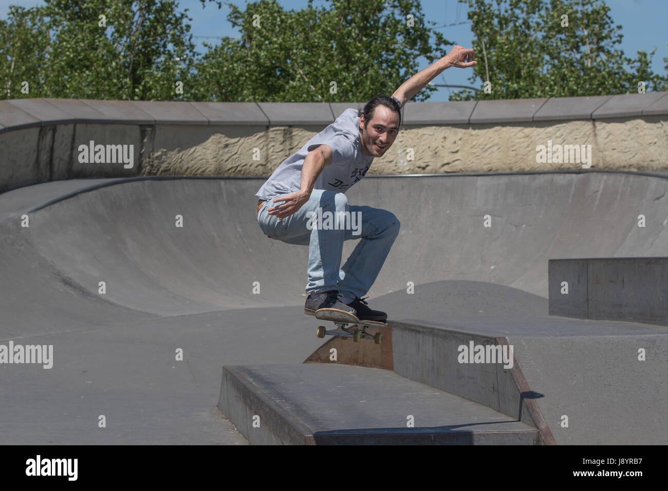 Handsome skateboarder jumping towards the camera in the air Stock Photo
