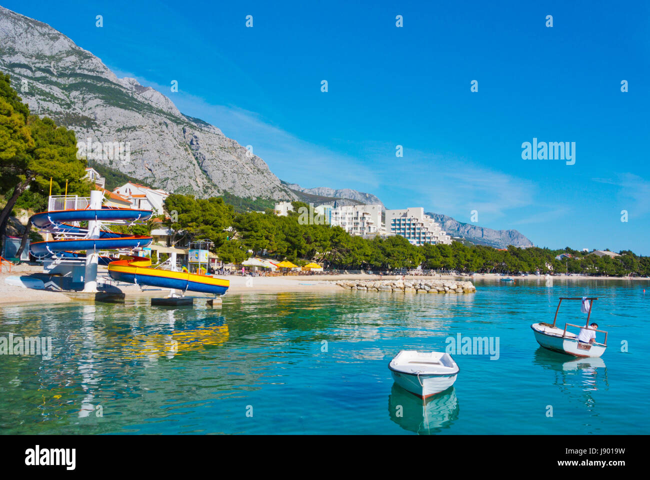 Plaza Donja Luka, the main beach, with boats and water slide, Makarska, Dalmatia, Croatia Stock Photo