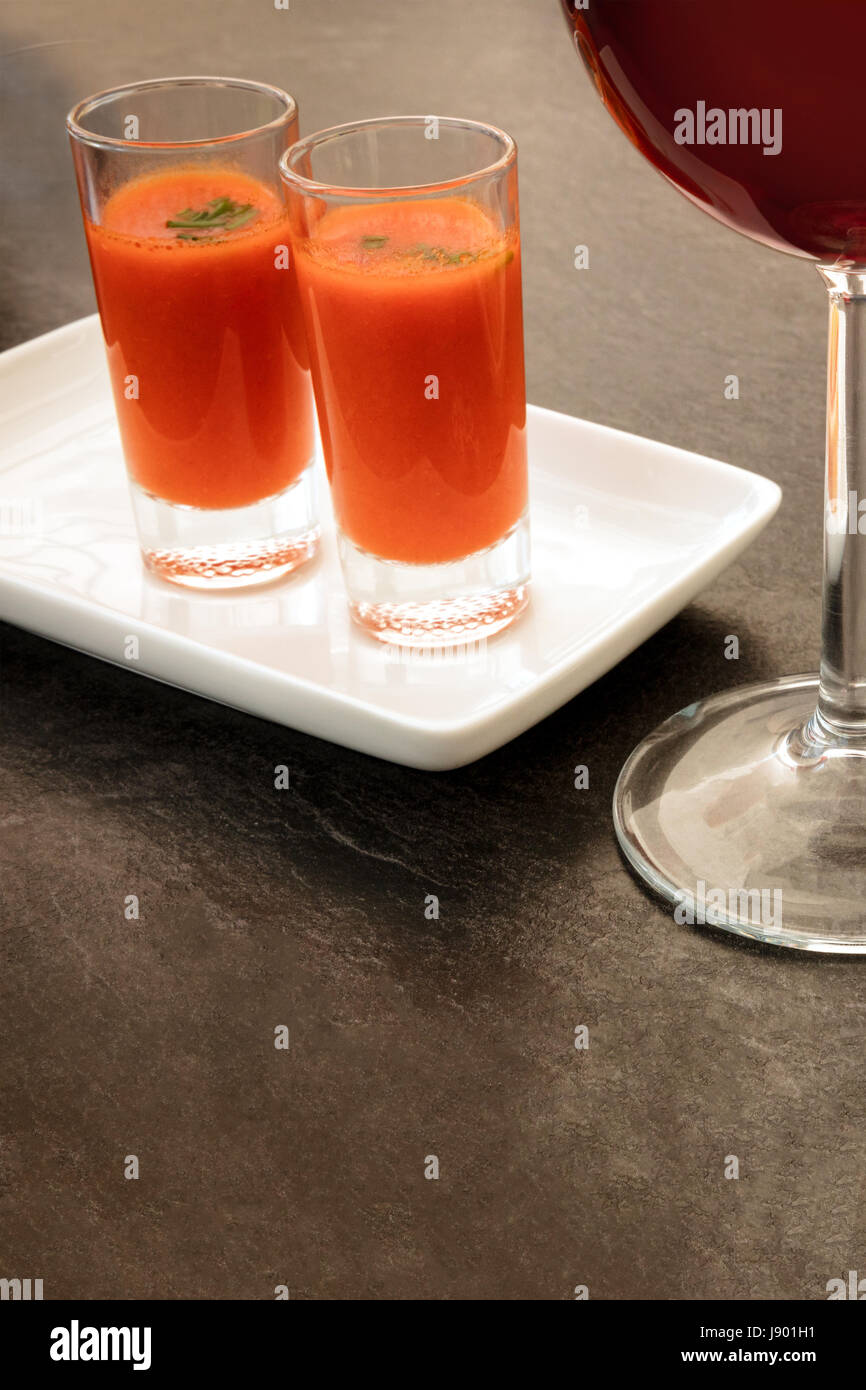 Spanish tapas in a modern bar. A glass of red wine and two shots of