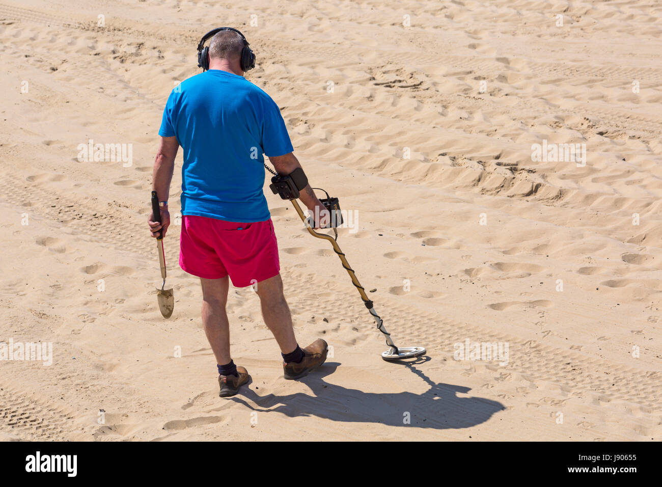 Man with metal detector at Bournemouth beach, Bournemouth, Dorset in