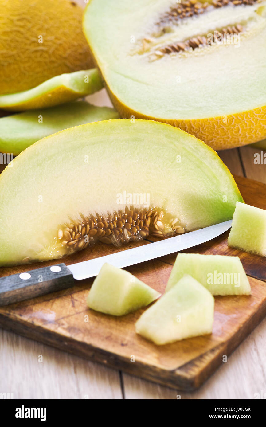 Sweet ripe muskmelon (galia melon) on wooden cutting board Stock Photo