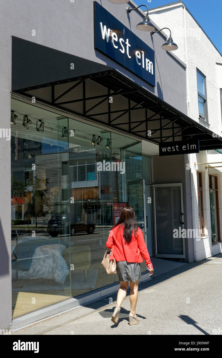 Young woman walking past a West Elm home decor store on south Granville Street shopping district in Vancouver, British Columbia, Canada Stock Photo