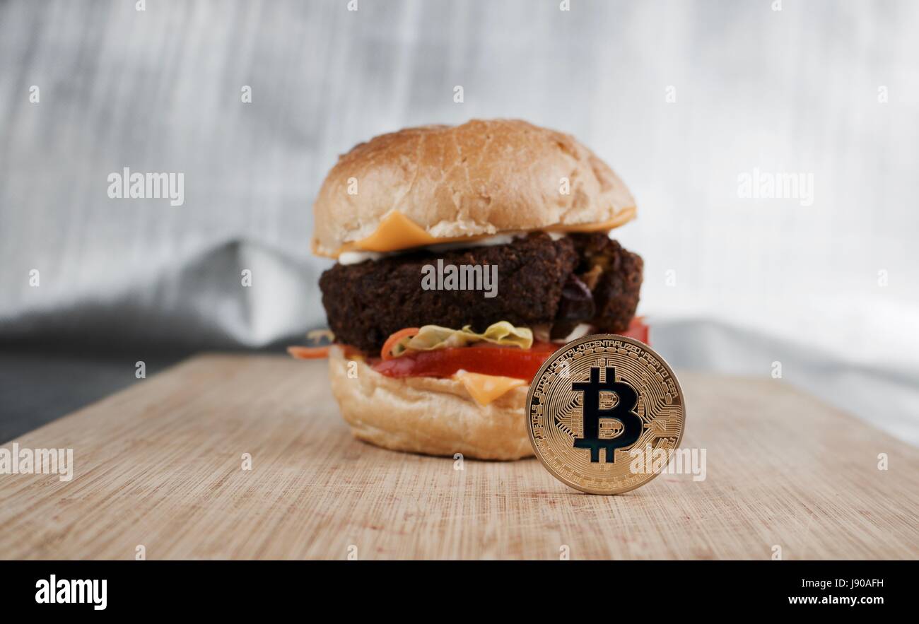Cryptocurrency gold bitcoin coin and tasty vegetarian burger Stock Photo -  Alamy