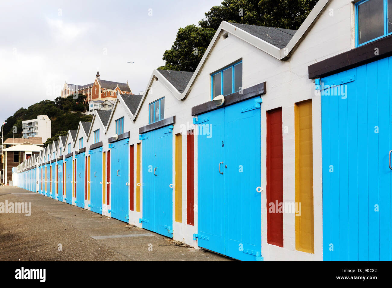 Beach huts / sailing huts Wellington waterfront, Oriental Parade, New Zealand, with monastery in background. Stock Photo
