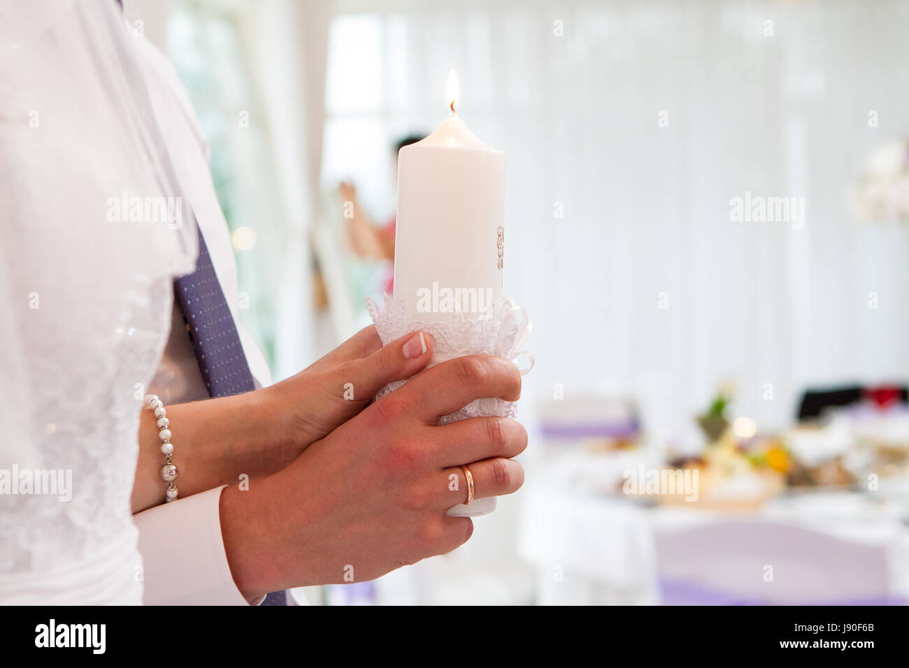 burning candles in the hands of the newlyweds Stock Photo Alamy