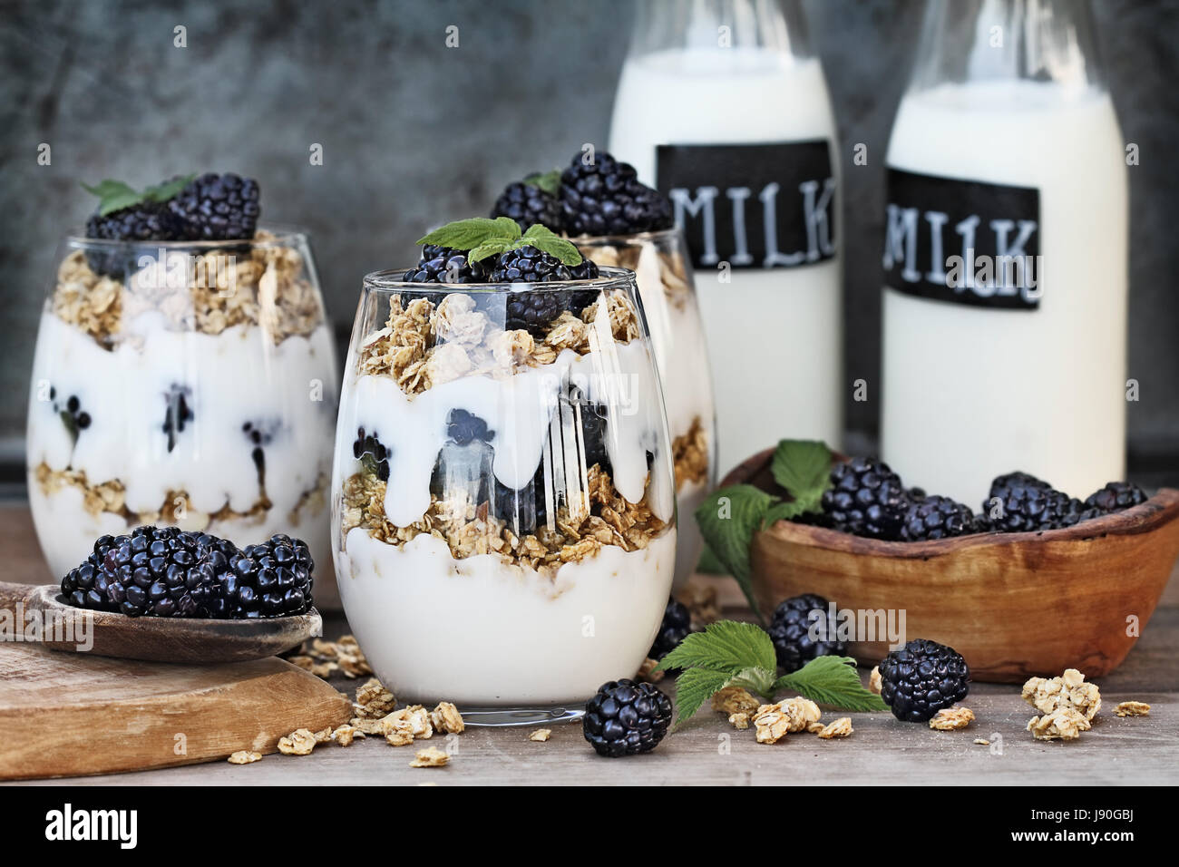 Blackberry parfaits made with Greek yogurt, granola and fresh blackberries. Extreme shallow depth of field with selective focus on parfait in foregrou Stock Photo