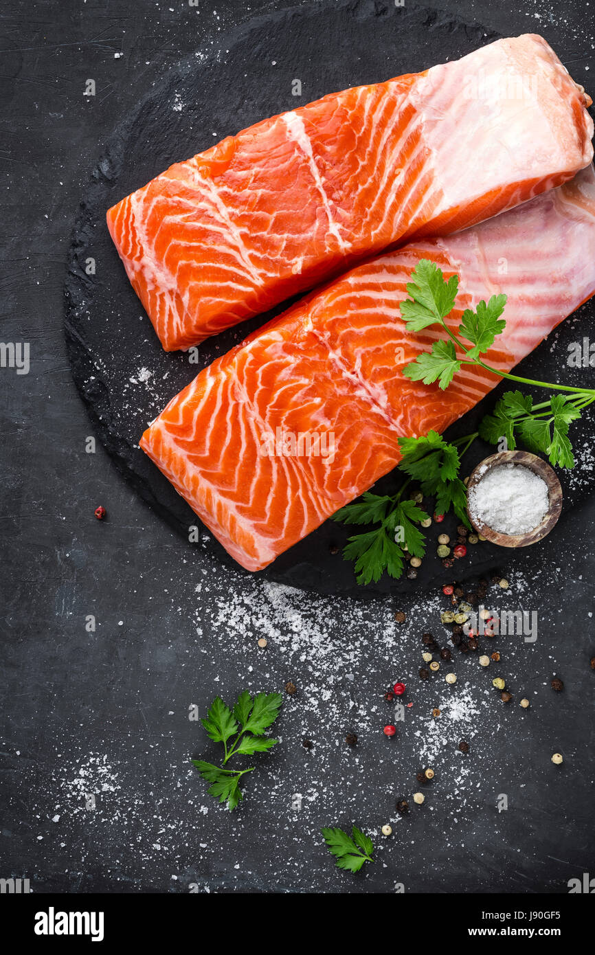 Raw salmon fish fillet on black background Stock Photo - Alamy