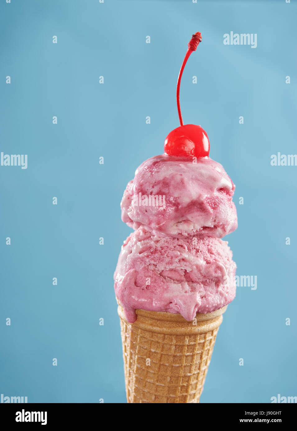 Pink ice cream cone with cherry Stock Photo