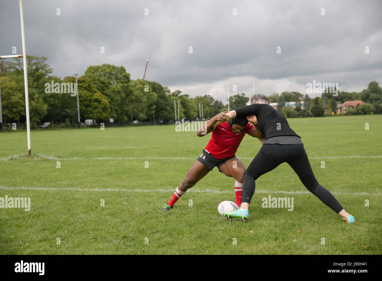 Maggie Alphonsi MBE, teaches Lucy Killgren the basics of rugby tackling. Stock Photo