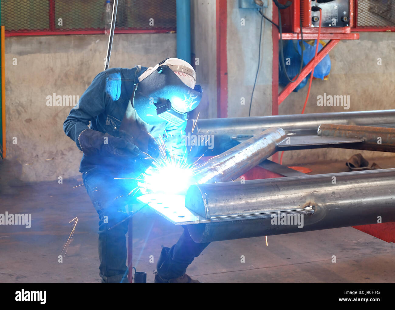 Man welding steel by skill.Men wear protective clothing during work. Stock Photo