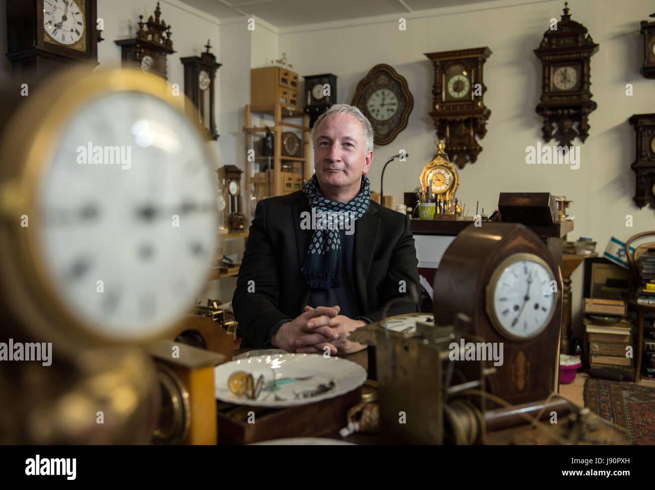 Mainz, Germany. 08th May, 2017. Dietmar Koester sits between old clocks in his workshop in Mainz, Germany, 08 May 2017. The man from Mainz is a skilled clock maker and specializes in the repair and restoration of old clocks. Photo: Andreas Arnold/dpa/Alamy Live News Stock Photo