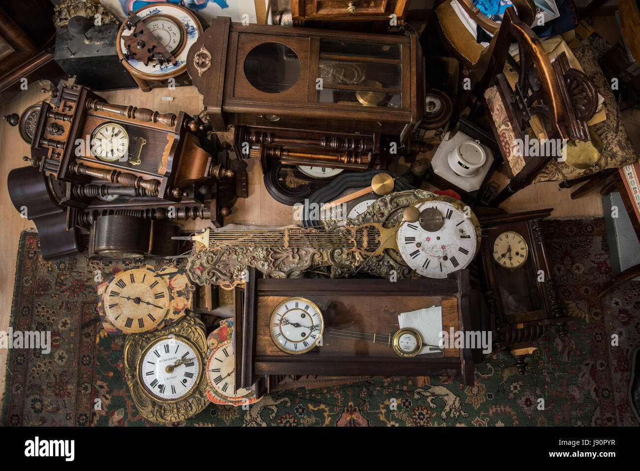 Mainz, Germany. 08th May, 2017. Clocls from different eras and of different designs piled on the floor in the workshop of Dietmar Koester in Mainz, Germany, 08 May 2017. The man from Mainz is a skilled clock maker and specializes in the repair and restoration of old clocks. Photo: Andreas Arnold/dpa/Alamy Live News Stock Photo
