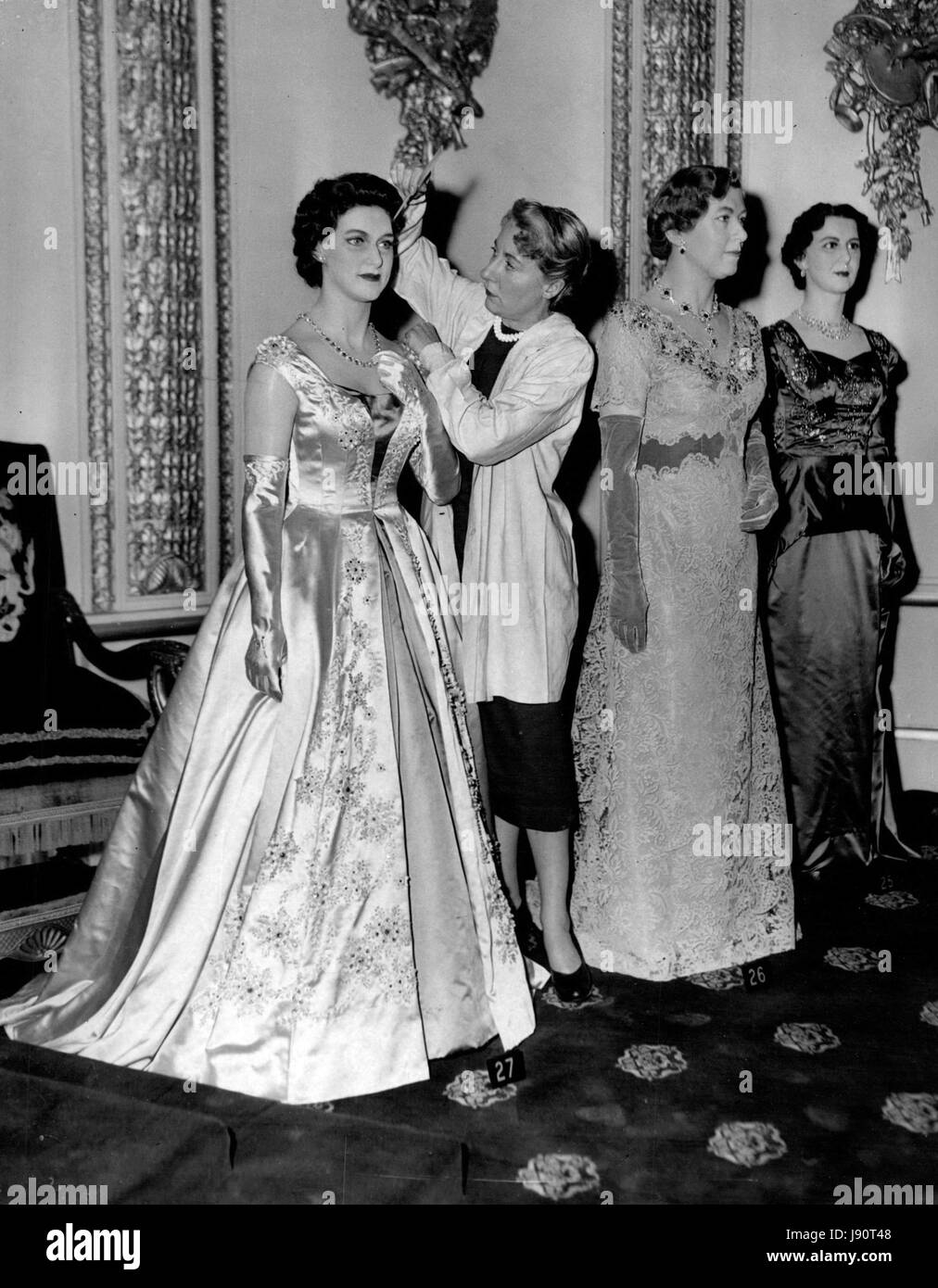 Mar. 03, 1956 - new Royal Models at Tussaud's: New models of the Queen. Princess Margaret and Princess Royal, were seen for the first time at this evening's press view of the new royal family group at Madame Tussaud's. The model of the Queen shows her wearing her Garter robes - and exact copy of those worn by the Queen. Modeld of the other Royal Ladies are wearing gowns specially designed by Norman Hertnell. Photo shows Miss Vera Bland, of Scarbrough, who is the hairdresser at Madame Tussaud's - seen putting the finishing touches to the new model of Princess Margaret. On right is the new model Stock Photo