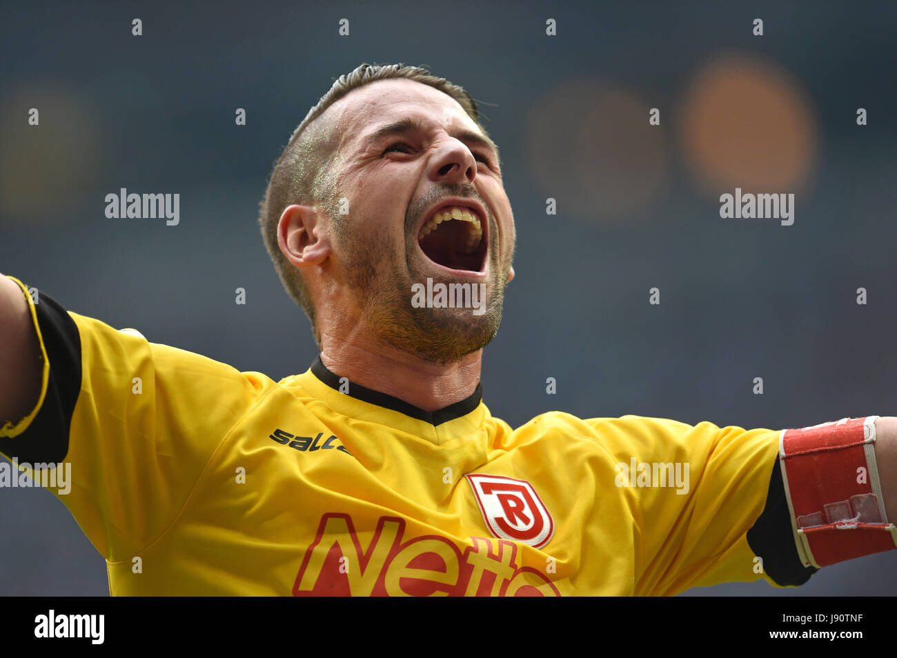 A security guard and Regensburg's goalkeeper Philipp Pentke pick up seats  that were thrown onto the turf during the German Bundesliga 2nd division  relegation soccer match between TSV 1860 Munich and Jahn