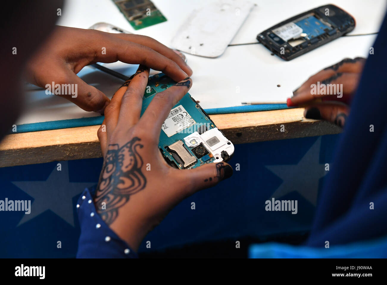 (170531) -- MOGADISHU, May 31, 2017 (Xinhua) -- Trainees practice mobile phone repairing at the training centre ELMAN, a non-government organization (NGO) which cooperates with the United Nations Children's Fund (UNICEF), in Mogadishu, Somalia, March 22, 2017. By the year of 2017, more than 1630 children and teenagers have taken vocational training courses such as automobile maintenance, basic electricity knowledge and circuit maintenance skills, mobile phone repairing and computer using. A vast majority of the students here were former child soldiers or affected by armed groups. The knowledge Stock Photo