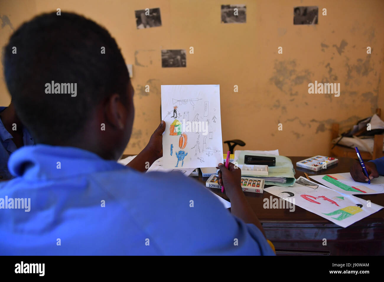(170531) -- MOGADISHU, May 31, 2017 (Xinhua) -- A boy looks at his drawing at the training centre ELMAN, a non-government organization (NGO) which cooperates with the United Nations Children's Fund (UNICEF), in Mogadishu, Somalia, March 22, 2017. By the year of 2017, more than 1630 children and teenagers have taken vocational training courses such as automobile maintenance, basic electricity knowledge and circuit maintenance skills, mobile phone repairing and computer using. A vast majority of the students here were former child soldiers or affected by armed groups. The knowledge and skills th Stock Photo