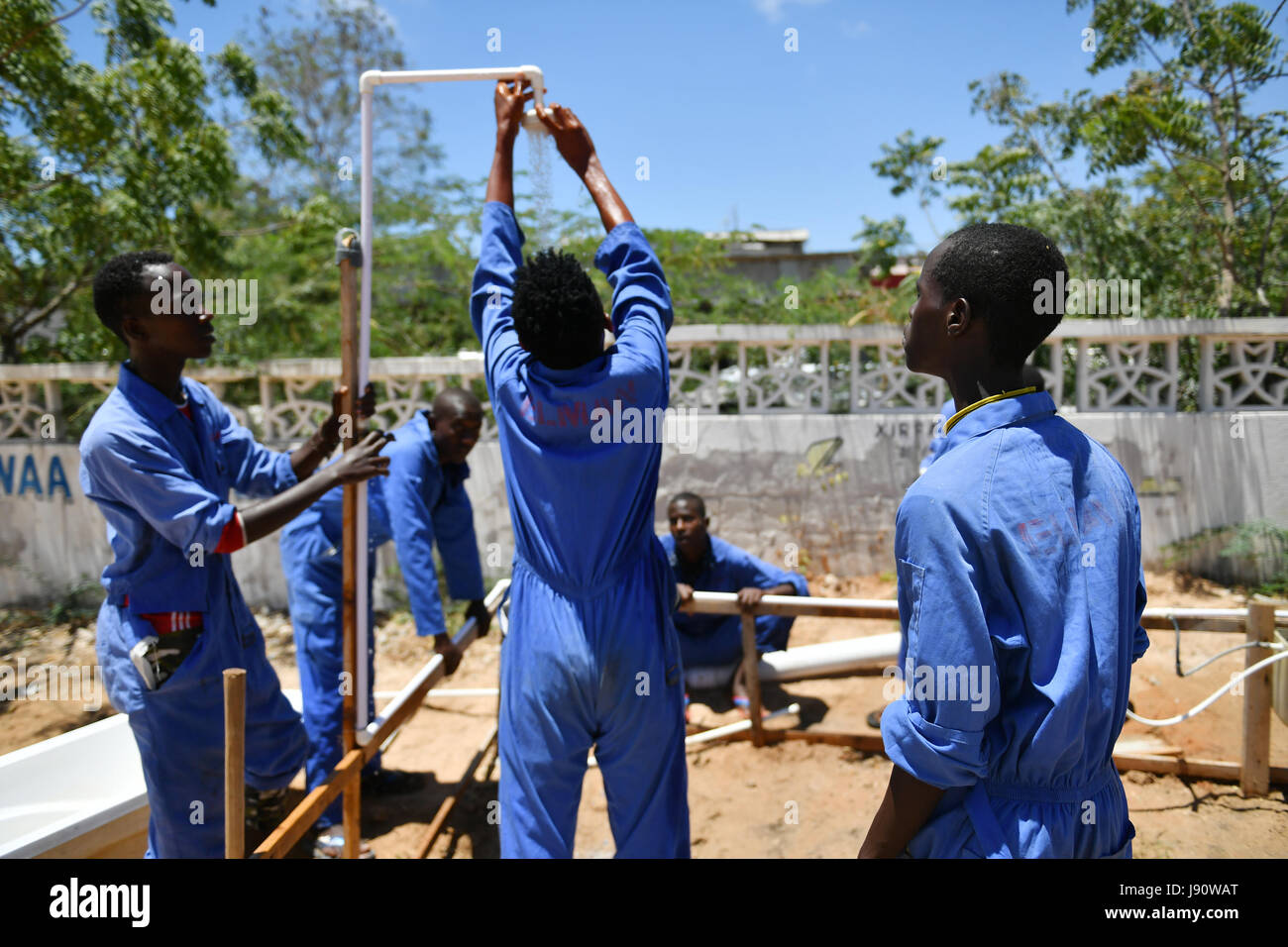 (170531) -- MOGADISHU, May 31, 2017 (Xinhua) -- Trainees test the shower head they installed during a class at the training centre ELMAN, a non-government organization (NGO) which cooperates with the United Nations Children's Fund (UNICEF), in Mogadishu, Somalia, March 22, 2017. By the year of 2017, more than 1630 children and teenagers have taken vocational training courses such as automobile maintenance, basic electricity knowledge and circuit maintenance skills, mobile phone repairing and computer using. A vast majority of the students here were former child soldiers or affected by armed gr Stock Photo