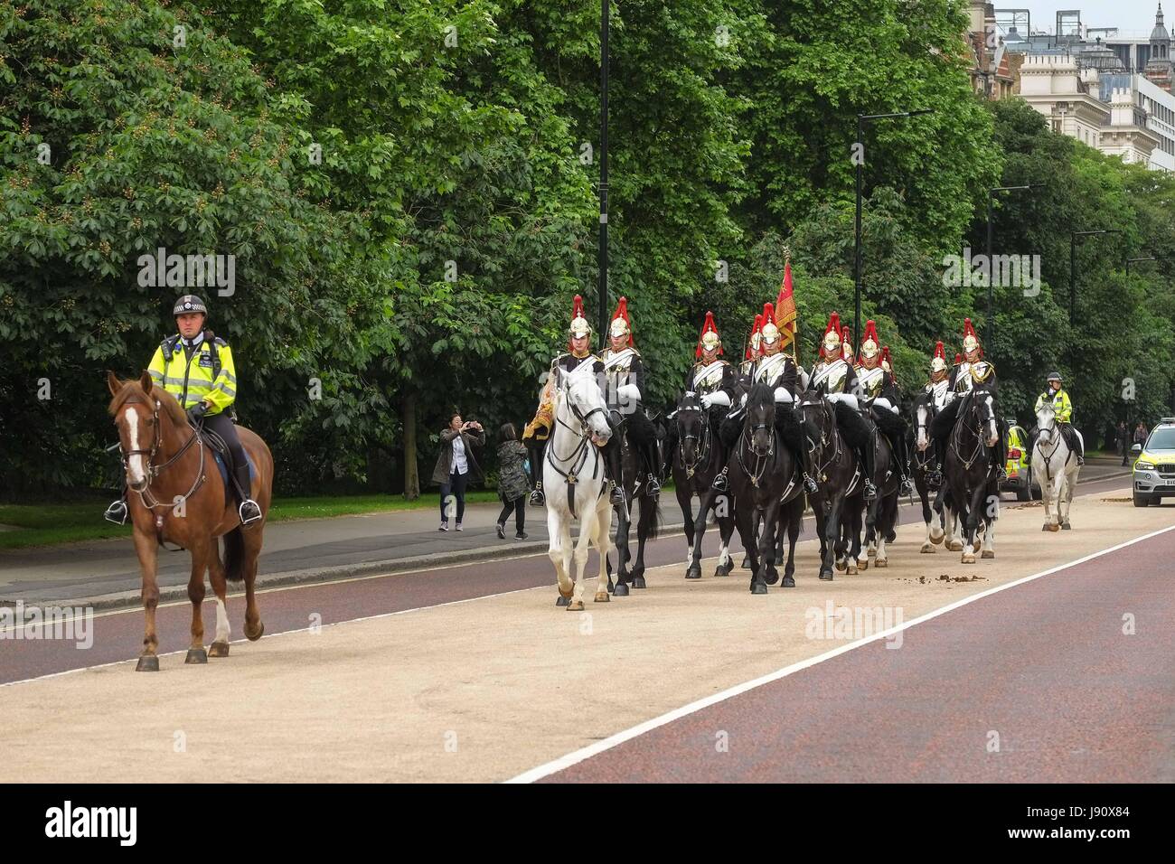 London, UK. 31st May 2017. The Household Cavalry ride through Hyde Park from their barracks in Knightsbridge towards House Guards Parade to Change the Guard a ceremony dating back over 350 years. Todays guard are the Blues and Royals. The mounted standard bearer signals the monarch is in residence. Credit: claire doherty/Alamy Live News Stock Photo