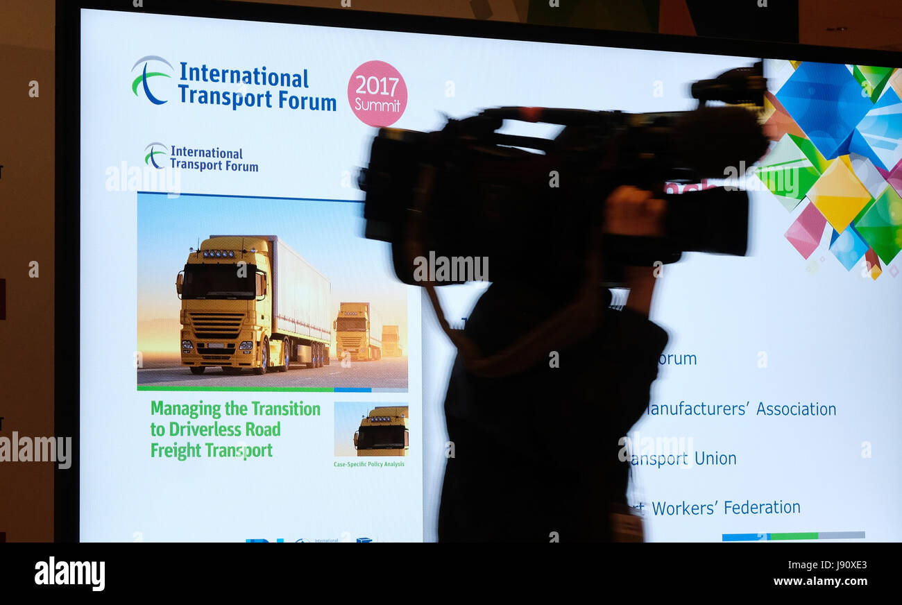 Leipzig, Germany. 31st May, 2017. A cameraman walks past a display at the International Transport Forum at the Congress Center in Leipzig, Germany, 31 May 2017. More than 1,200 participants from 70 nations are expected in Leipzig from 31 May to 2 June 2017. The guestlist includes ministers of traffic from multiple countries, representatives of international traffic organisations and decision makers from politics, economy and associations. Credit: dpa picture alliance/Alamy Live News Stock Photo