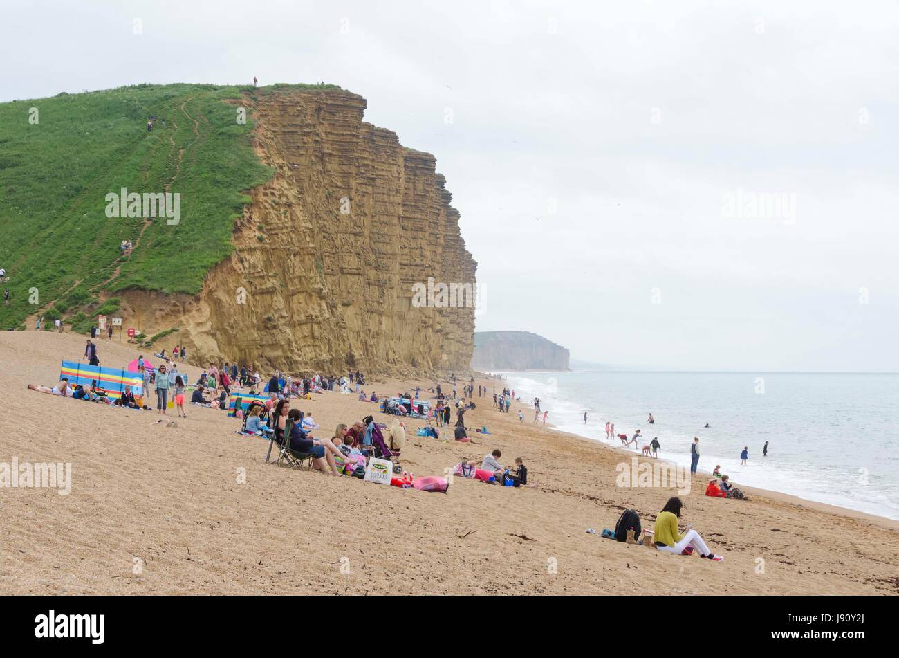 West Bay, Dorset, UK.  31st May 2017.   UK Weather.   Holidaymakers visiting the seaside resort of West Bay in Dorset, enoying the warm but overcast conditions on the beach during the half term holidays.  Photo Credit: Graham Hunt/Alamy Live News Stock Photo