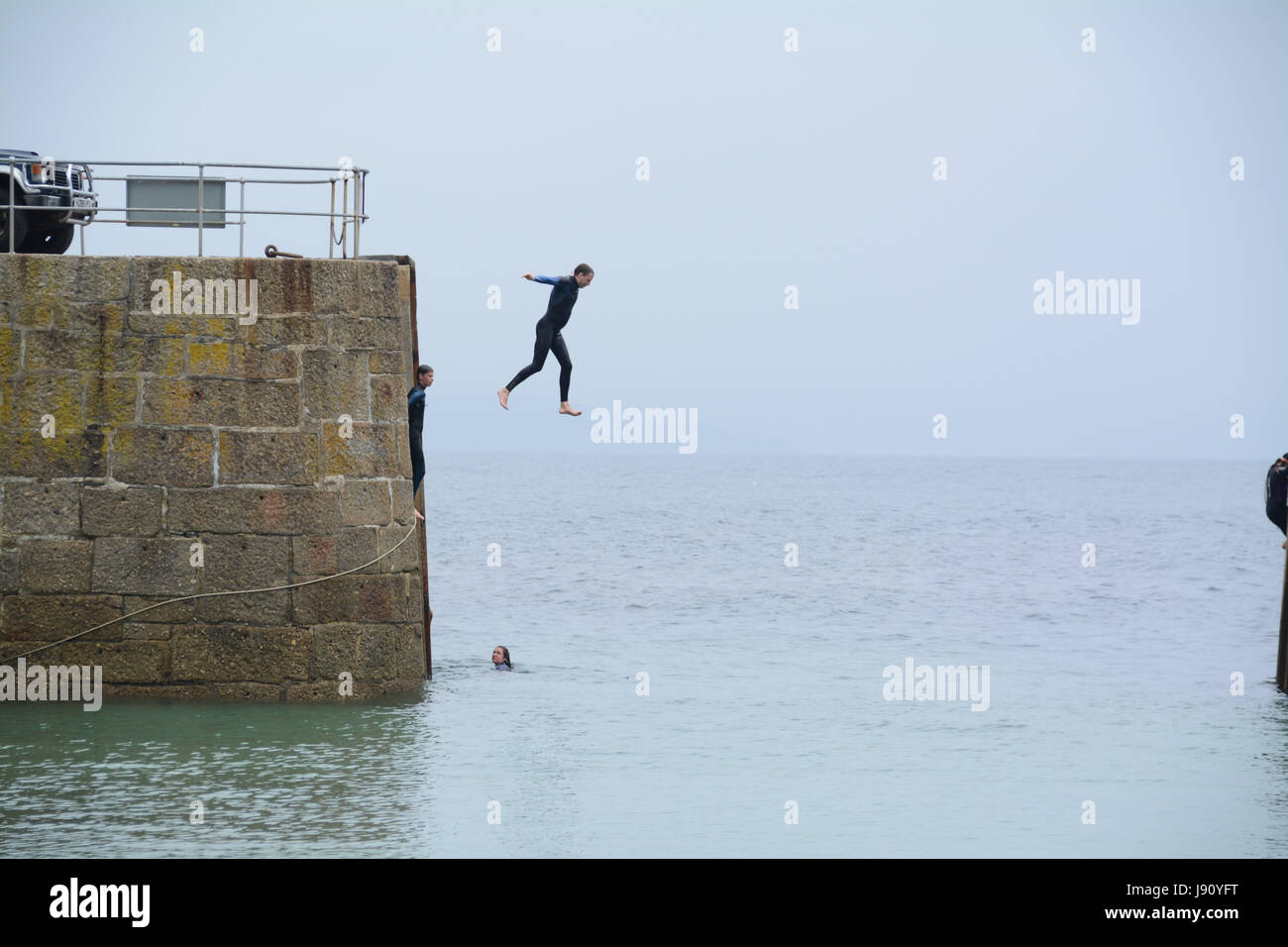 Mousheole Harbour, Cornwall,UK. 31st May 2017. UK Weather. After a misty start to the day, the weather is getting warmer on the Cornish coast, with families enjoying the beach, and people jumping off the harbour wall into the sea. Credit: cwallpix/Alamy Live News Stock Photo