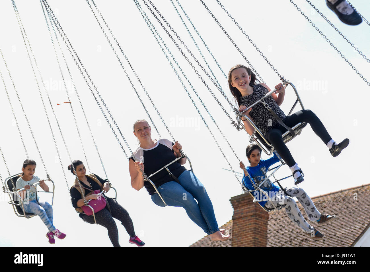 London, UK. 31 May 2017. Customers fly overhead on a spinning ride ...