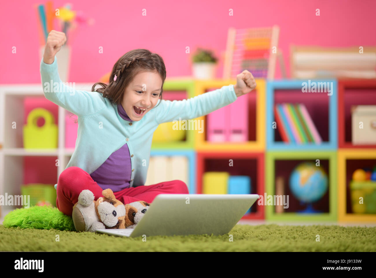Cute little girl with modern laptop on floor Stock Photo - Alamy