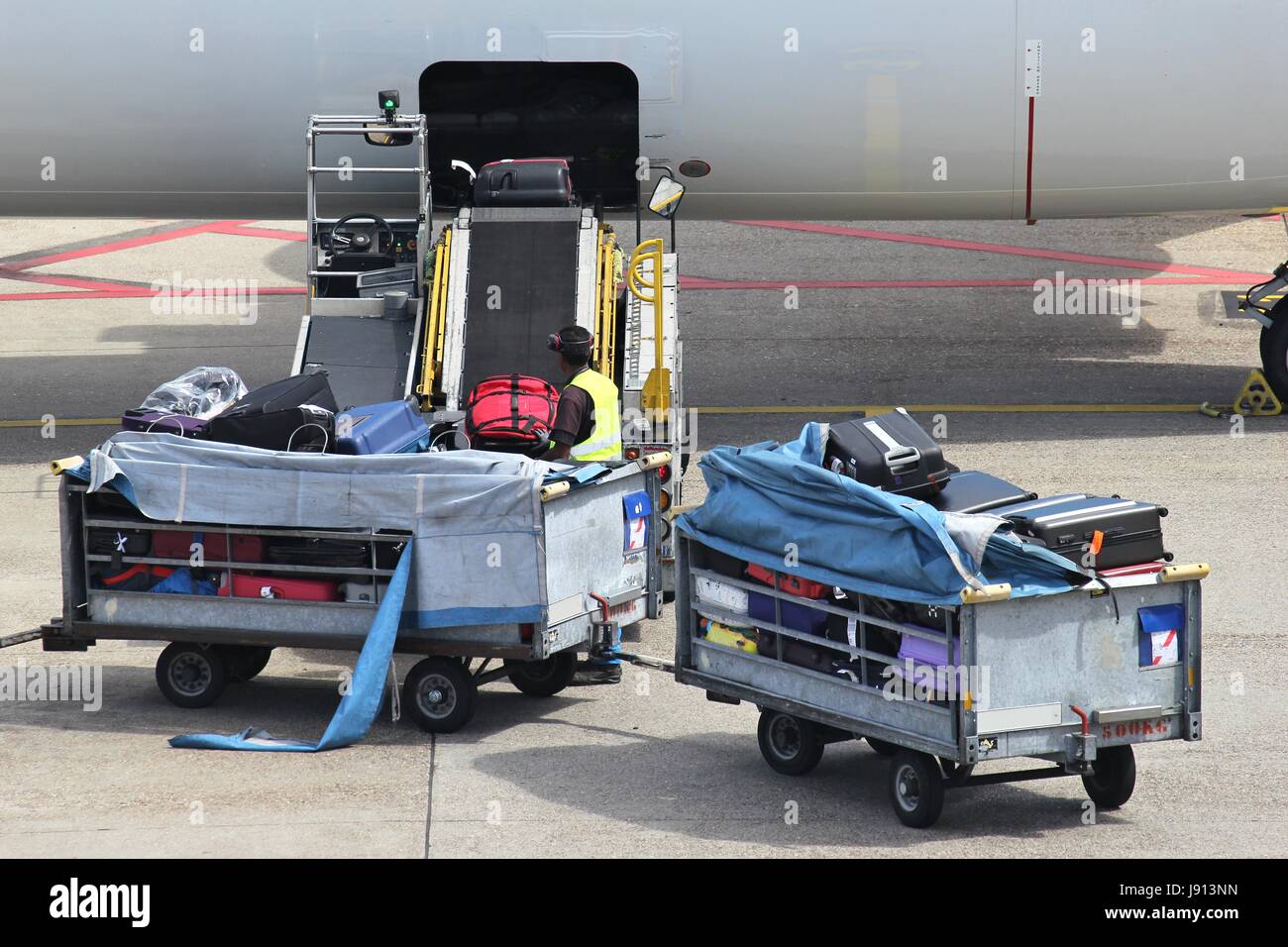 loose luggage being loaded into narrow body aircraft Stock Photo