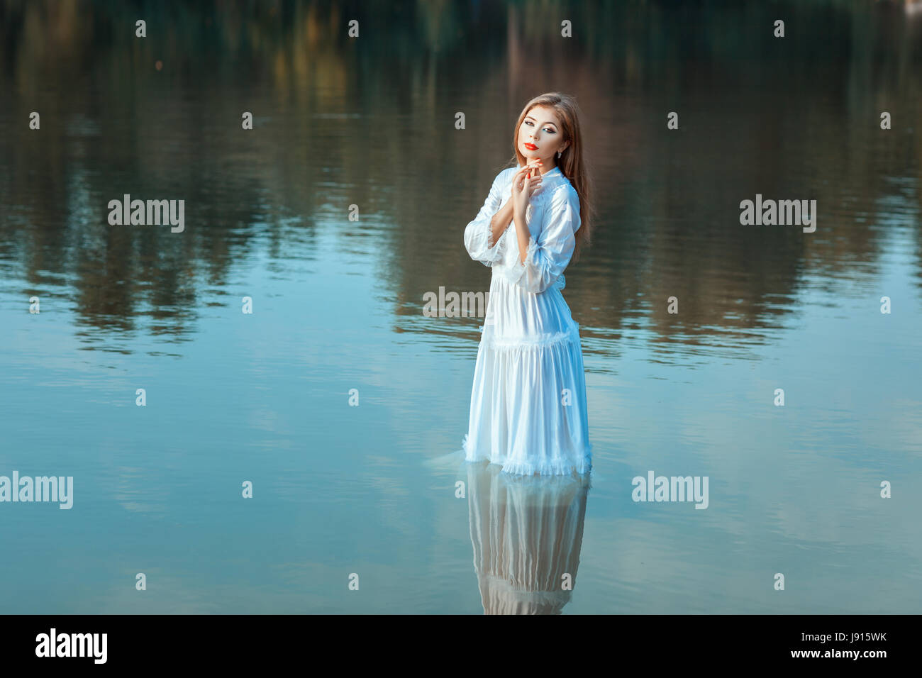 Girl in a white dress standing in the lake water Stock Photo - Alamy