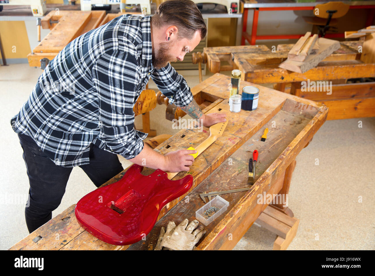 Craftsman sanding a guitar neck in wood at Stock Photo Alamy