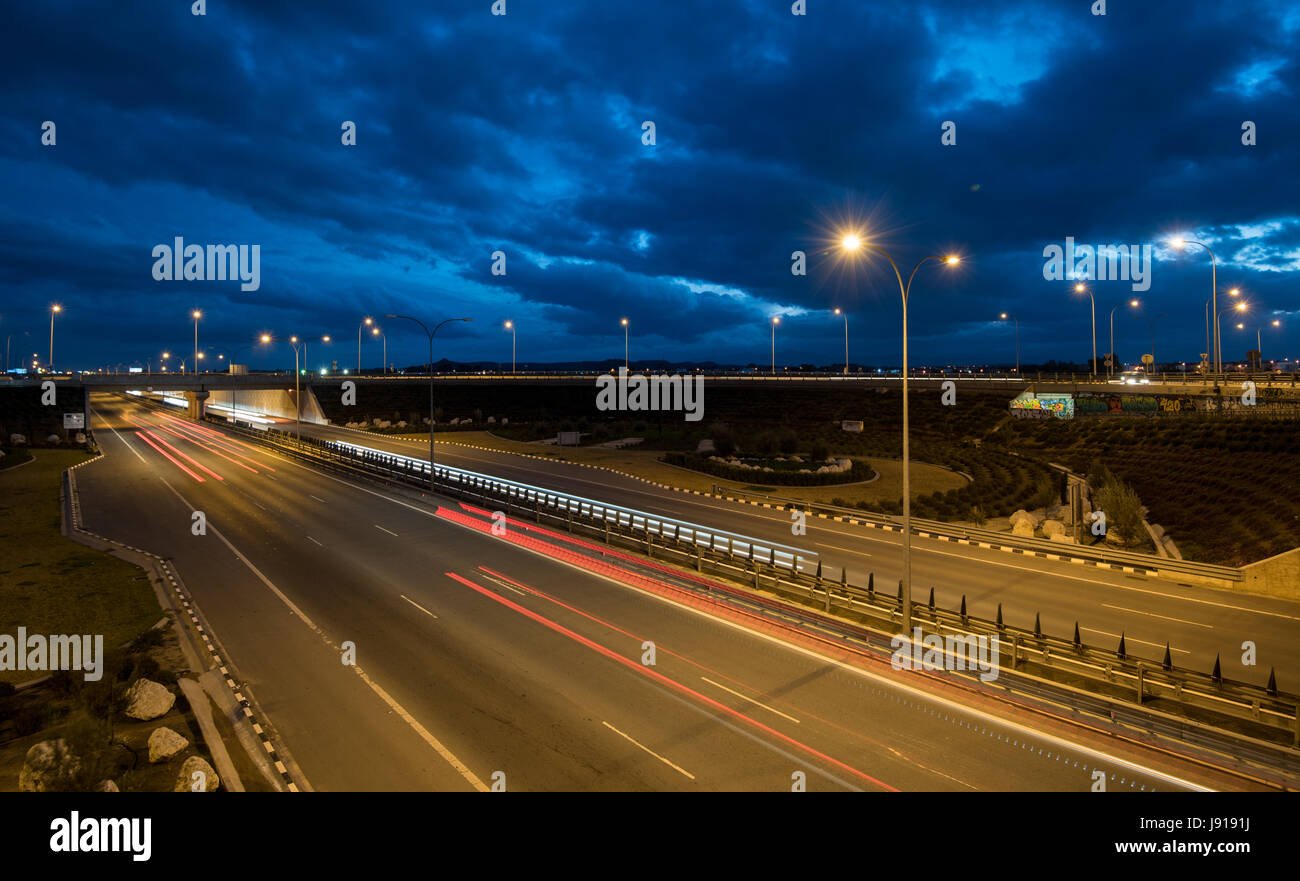 Light trails from cars moving fast late in the evening on a motorway of Nicosia, Cyprus. Concept of high speed. Stock Photo