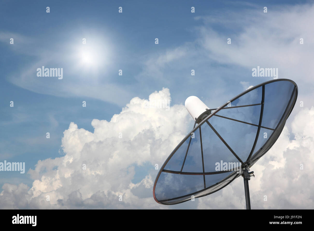 Black Satellite dish on blue sky background. Stock Photo