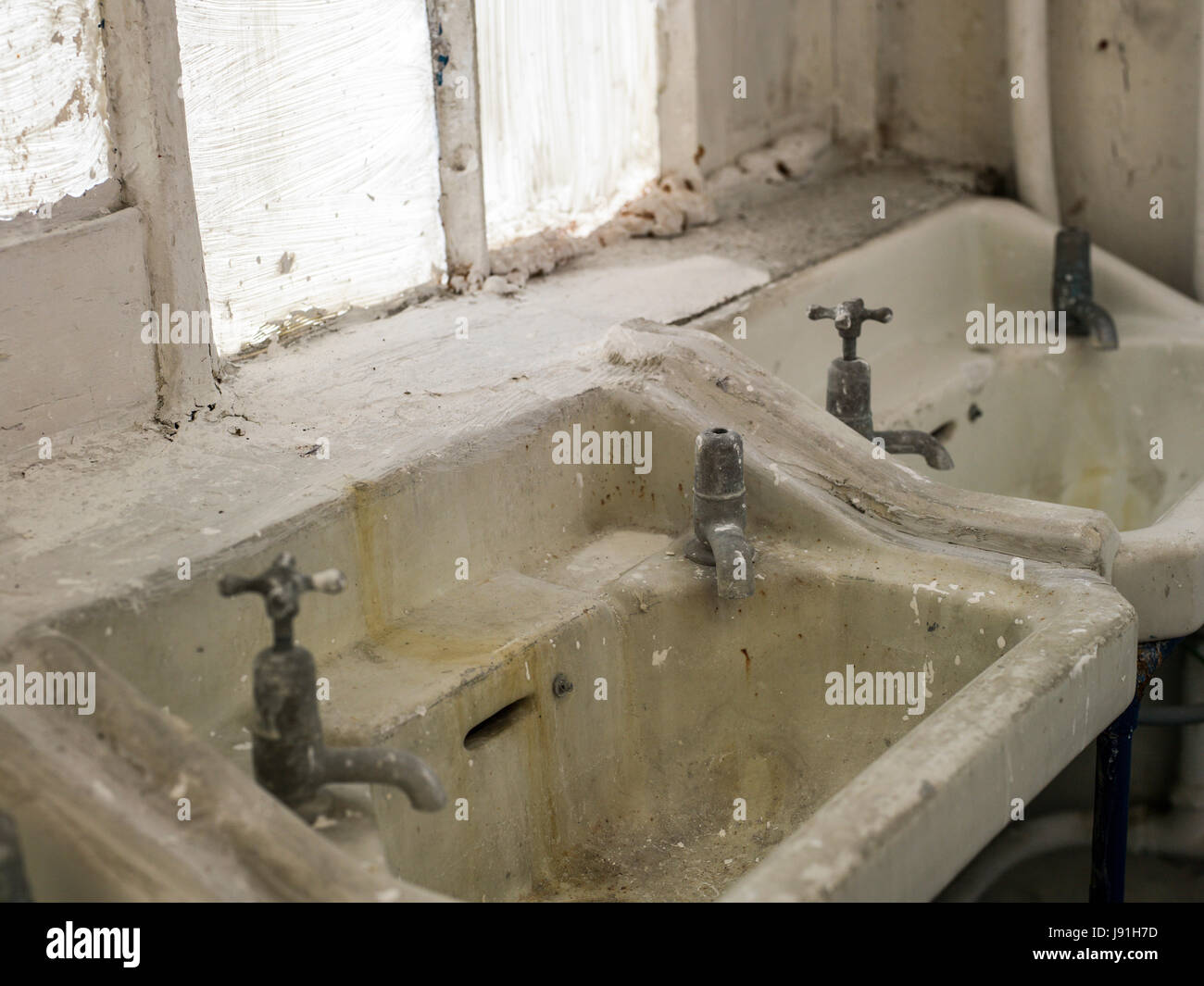 dirty white bathroom sinks in toilet block Stock Photo