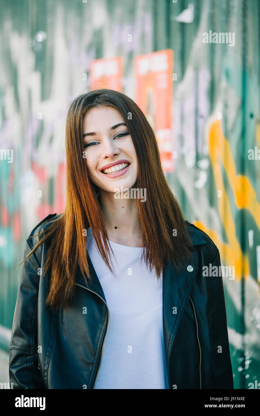 Young beautiful brunette walk in a city against a grundge background Stock Photo