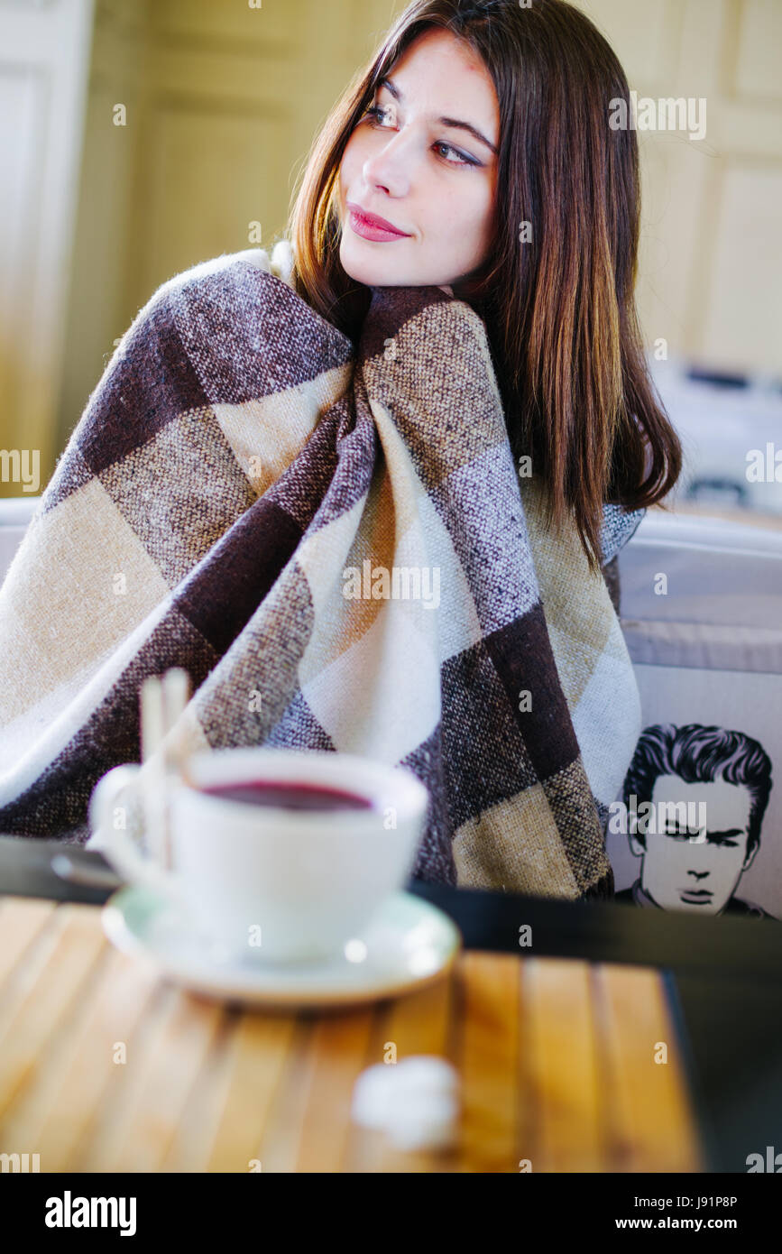 Beautiful brunette drink tea and warm herself Stock Photo